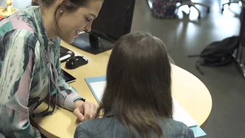 Close-up of teacher helping student in a classroom 動画素材 76567120