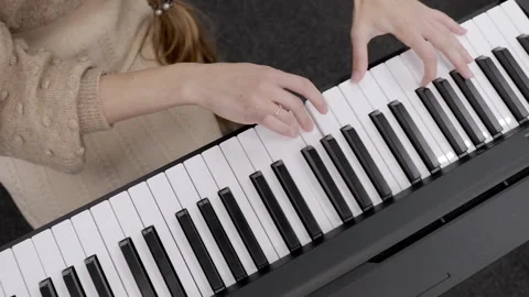 A close-up of the teacher's hands playing the synthesizer, showing mastery. Stock Footage 239475356