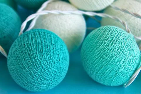 Close up of teal and white string lights with textured spherical bulbs Stock Photos