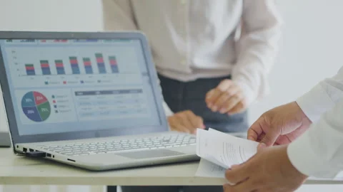 Close-up of a team analyzing metrics and documents in an office using tablets Stock Footage 347969821