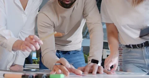 Close up of team of man and two women standing over the table with charts Stock Footage 180056394