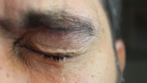 Close up, a tear falls from a man's eye while he is crying Stock Footage 141135993