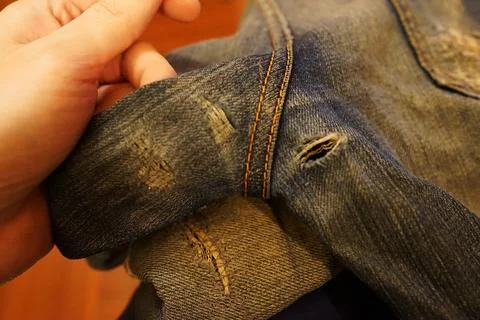 Close up tear in ripped denim jeans 스톡 사진