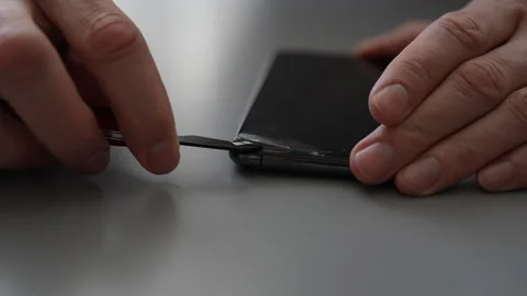 Close-up of technician carefully removing broken tempered glass screen protector Stock Footage 297632346