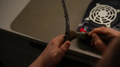 Close-up of technician cleaning dust and debris from game console component Stock Footage 307447573