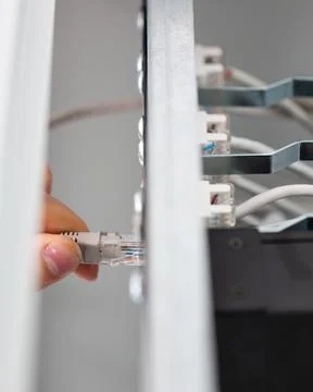 Close up of technician connecting network cable to check server. Stock Photos