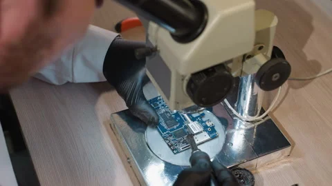 Close-Up of Technician Examining Circuit Board Under Microscope in Electronics Video stock 283122208