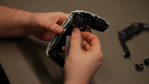 Close-up of technician hands examining internal components of disassembled video Stock Footage 310628339