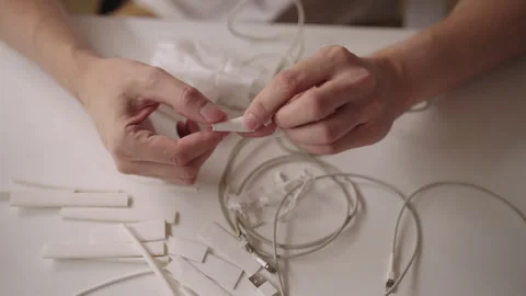 Close-up of technician hands inspecting and repairing damaged white charging Stock Footage 317306931
