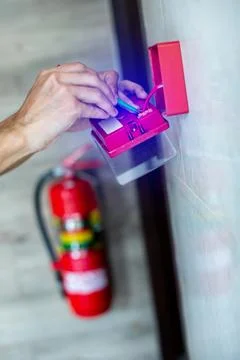 Close-up of technician hands installing and wiring a red fire alarm manual .. Foto stock