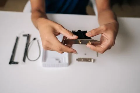 Close-up of technician hands installing wi-fi module with heatsink into computer Stock Photos