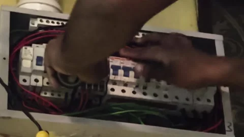 Close-up of technician hands repairing components inside electrical box. Vidéo 346911156