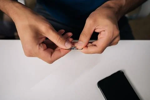 Close-up of technician hands replacing sim card in smartphone, providing 写真素材