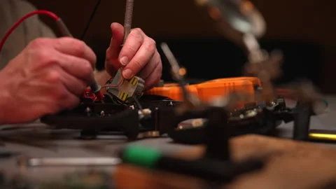 Close-up of technician hands soldering components onto circuit board of Stock Footage 302564628