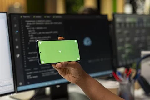 Close up of technician looking at code on isolated screen smartphone 写真素材