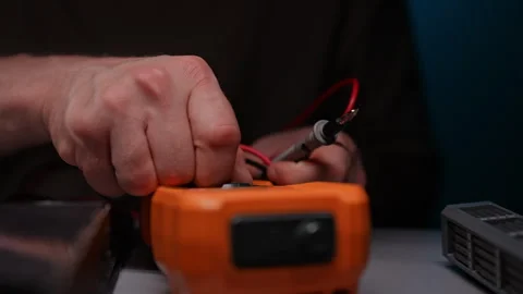 Close-up of technician male operating digital multimeter, connecting probes and Stock Footage 290922808