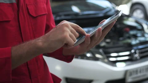 Close-up technician man hand using tablet analyzing car problems in auto re.. Stock Footage 257693535