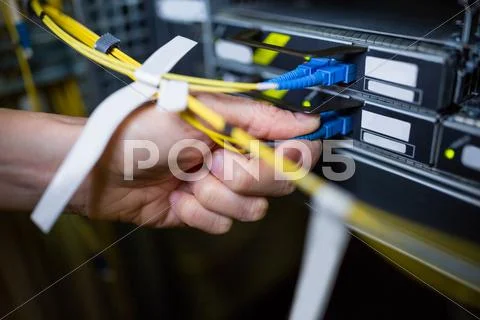 Close-Up Of Technician Plugging Patch Cable In A Rack Mounted Server