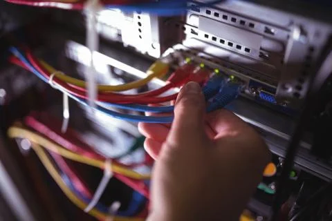 Close-Up of technician plugging patch cable in a rack mounted server Stock Photos