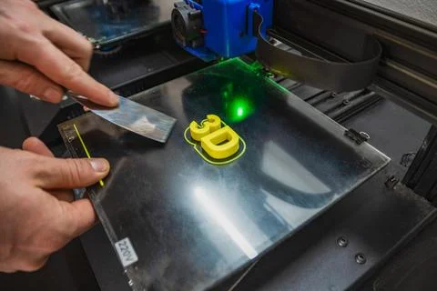 Close-up of technician removing finished 3d piece. Stock Photos