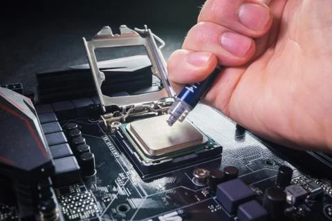 Close up to technician squeezing or application the thermal paste compound on Stock Photos