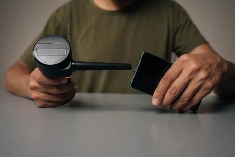 Close-up of technician using compressed air blower to clean charging port of Stock Photos