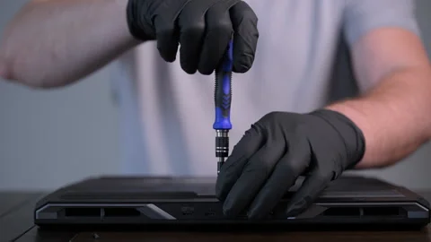 Close-up of technician using a screwdriver to open computer back cover and Stock Footage 326085524
