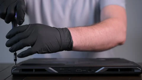 Close-up of technician using a screwdriver to open computer back cover and Stock Footage 326181479