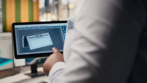 Close up of technician using tablet to create solar powered device design Stock Photos