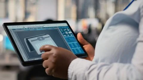 Close up of technician using tablet to create solar powered device design 写真素材