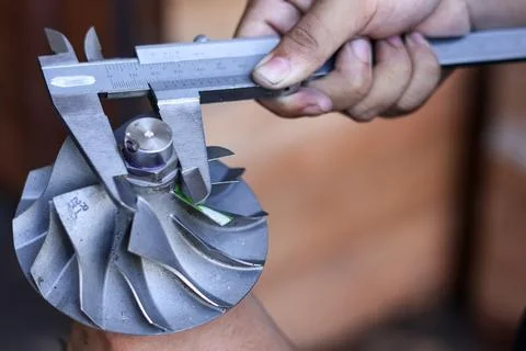 Close up of a technician using a vernier caliper to measure a turbocharger .. Stock Photos