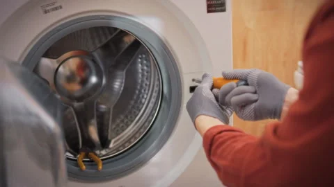 A close-up of a technicians gloved hands unscrewing a bolt from the body of Stock Footage 340790344