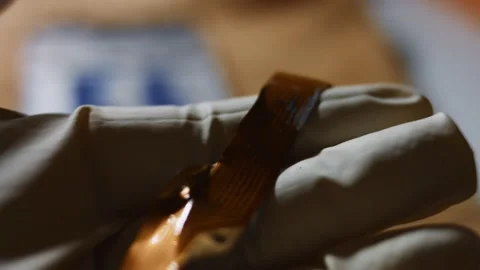 Close-up of technician's hand holding and analyzing a detail of a broken Stock Footage 144935998