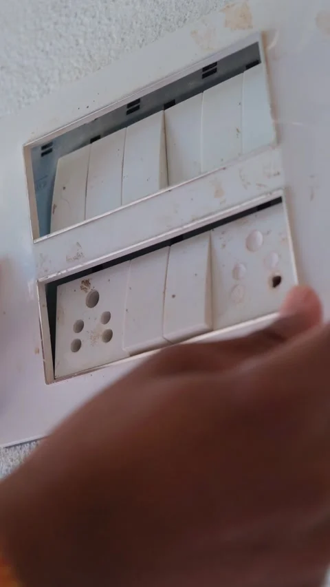 Close-up of a technician's hand removing a modular switchboard cover plate 動画素材 332998168