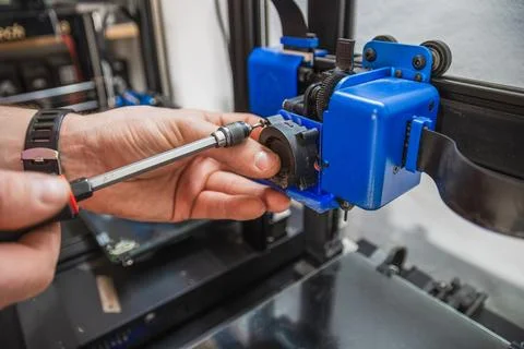 Close-up of technician's hands doing maintenance on 3D printer. Stock Photos