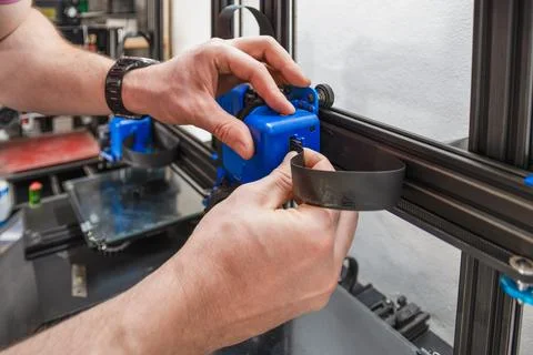 Close-up of technician's hands doing maintenance on 3D printer. Stock Photos