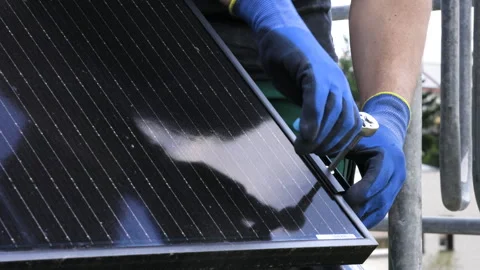 Close-up of a technician's hands installing a solar panel on the roof of a house Stock Footage 244208392