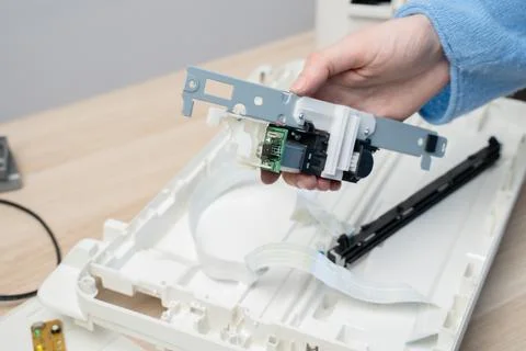 Close-up of a technician's hands repairing a flatbed scanner printer componen Stock Photos