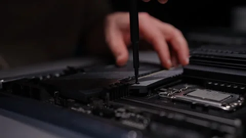 Close-up of technicians hands unscrewing cover on computer motherboard with Stock Footage 290923067