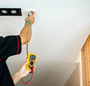 Close-up of technicians using a digital multimeter to test voltage on a fir.. Foto stock