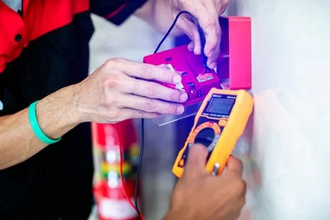 Close-up of technicians using a digital multimeter to test voltage on a fir.. Foto stock