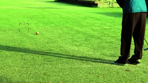 Close-up of tee shot of an old man playing croquet Stock Footage 278282434