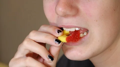 Close up of teen girl eating CBD infused gummy. . Stock Footage