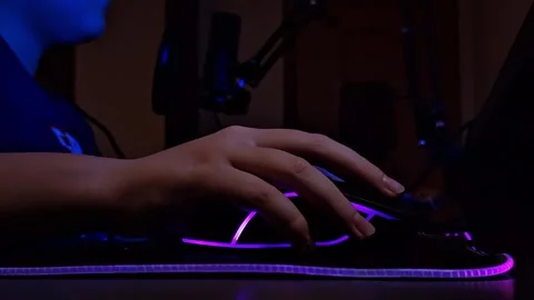 Close up of teen hand uses a computer mouse with neon lighting, bottom view, in Video stock 271081889
