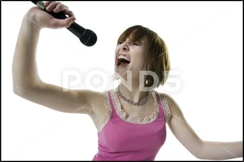 Close-up of a teenage girl singing into a microphone Stock Photos