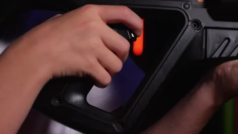 Close-up of a teenagers hand on the trigger of a weapon while playing laser tag Stock Footage 322215526
