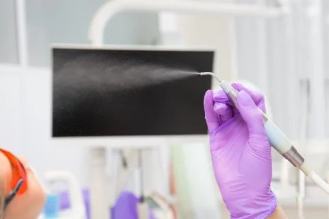 Close-up teeth airflow tool in the hand. Stock Photos