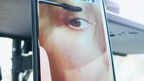 Close-up in a telephone mirror of a woman's face applying mascara Stock Footage 257237781
