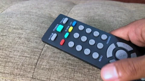 Close up of a television remote control held by a man's hand Stock Footage 232175805