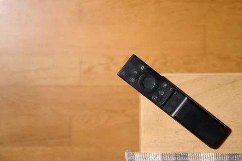 Close-up of a television remote control resting on a table. Stock Photos